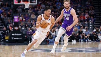SACRAMENTO, CALIFORNIA - MARCH 20: Devin Booker #1 of the Phoenix Suns dribbles the ball up court against Domantas Sabonis #10 of the Sacramento Kings in the first quarter at Golden 1 Center on March 20, 2022 in Sacramento, California. NOTE TO USER: User expressly acknowledges and agrees that, by downloading and/or using this photograph, User is consenting to the terms and conditions of the Getty Images License Agreement. (Photo by Lachlan Cunningham/Getty Images)