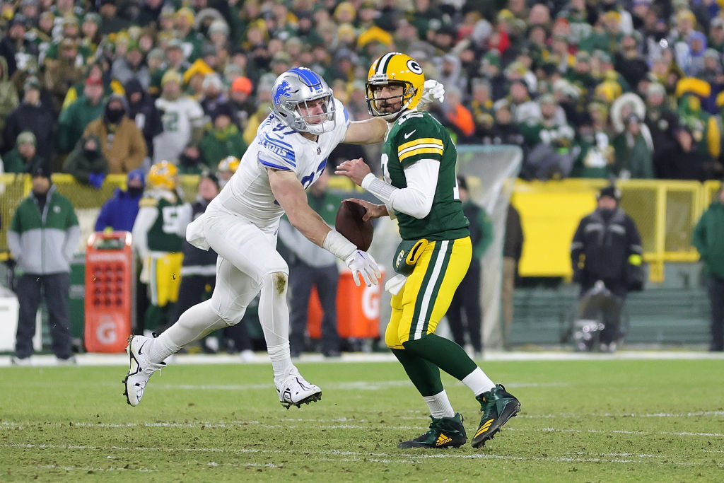 Aaron Rodgers #12 of the Green Bay Packers is sacked by Aidan Hutchinson #97 of the Detroit Lions d...