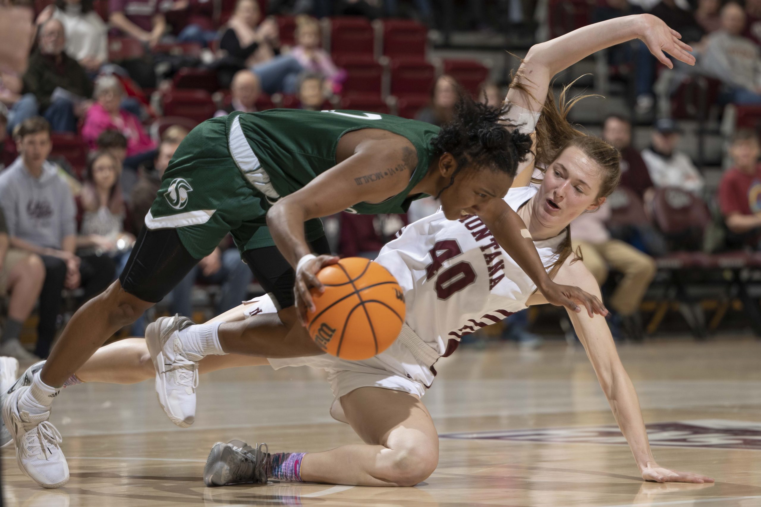 Kahlaijah Dean #0 of the Sacramento State Hornets trips over Dani Bartsch #40 of the Montana Grizzl...