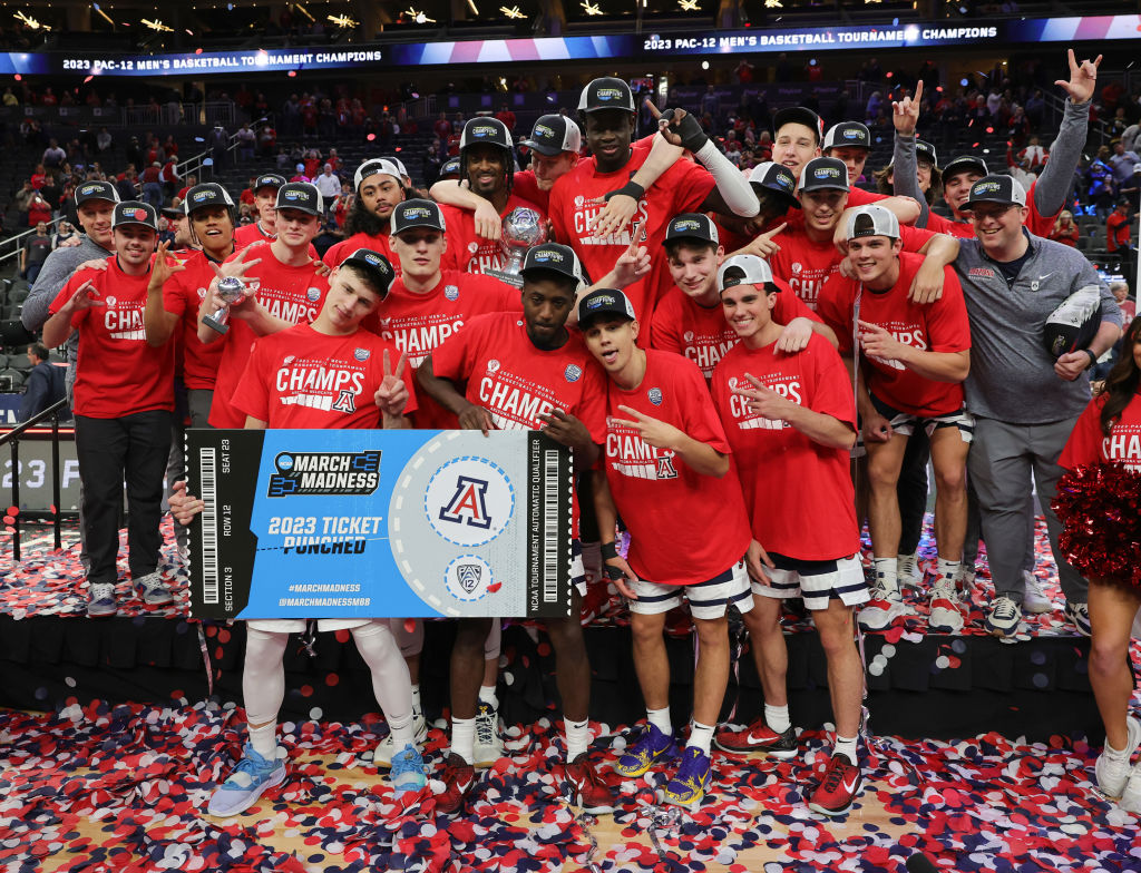 The Arizona Wildcats pose with a ceremonial NCAA tournament ticket as they celebrate their 61-59 vi...