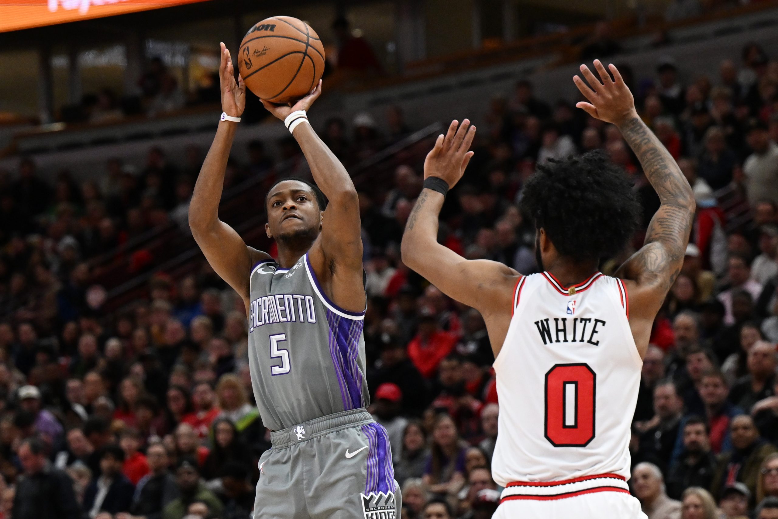 Sacramento Kings guard De'Aaron Fox shoots a 3-pointer against Coby White #0 of the Chicago Bulls i...