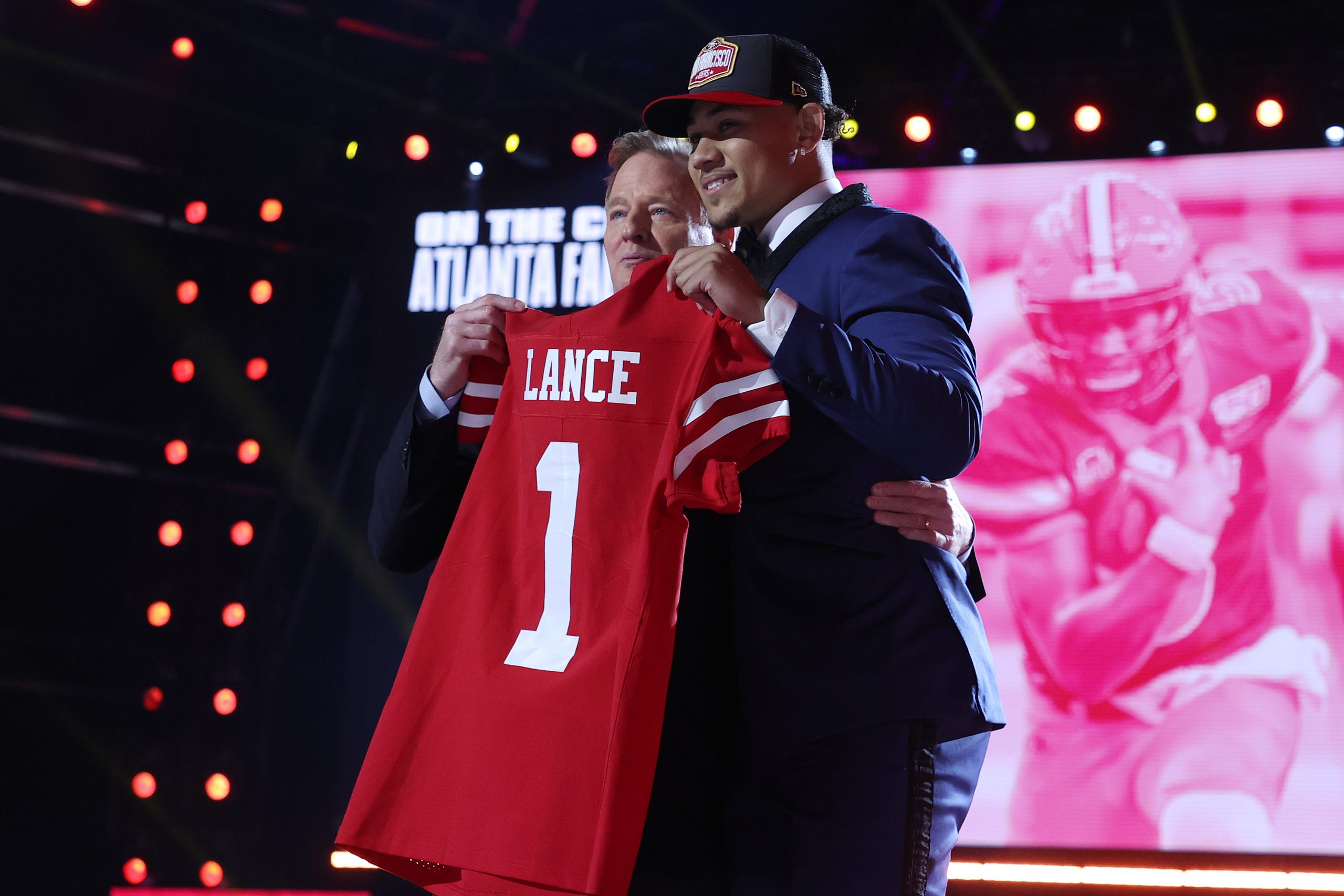 Trey Lance poses with NFL Commissioner Roger Goodell onstage after being selected third by the San ...