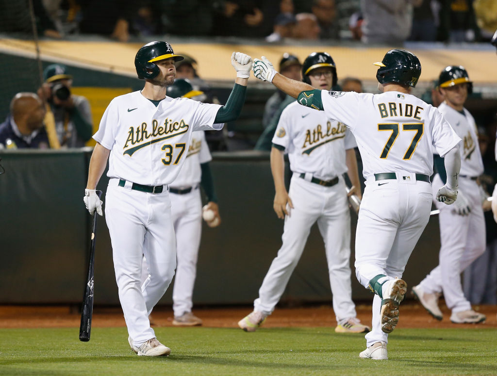 Jonah Bride #77 of the Oakland Athletics celebrates with Cal Stevenson #37 after hitting a solo hom...