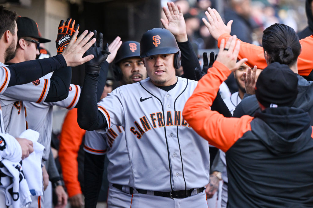 Wilmer Flores #41 of the San Francisco Giants celebrates in the dugout with teammates after his two...