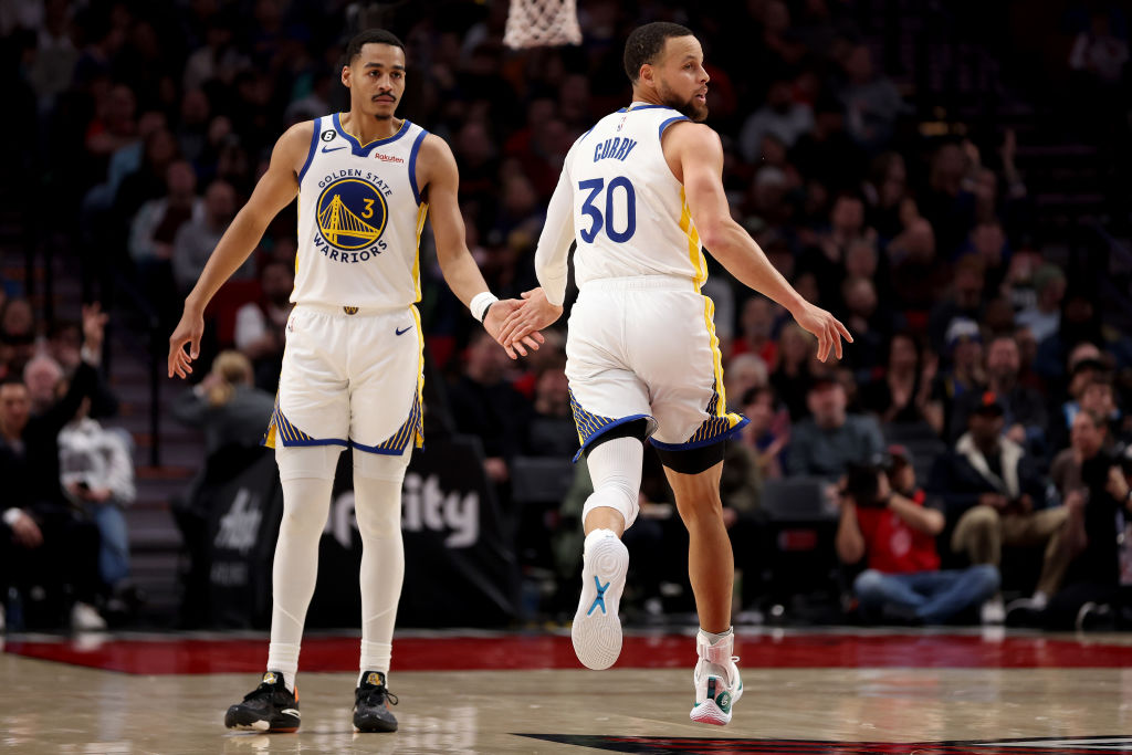 Jordan Poole #3 and Stephen Curry #30 of the Golden State Warriors react during the first quarter a...