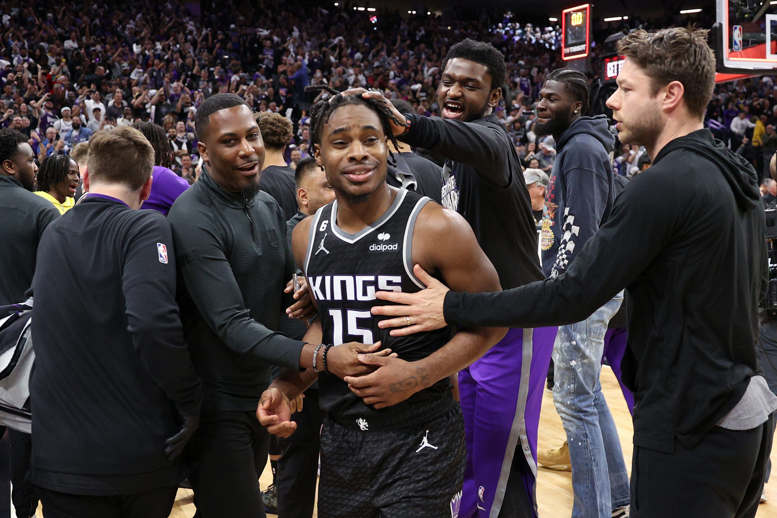 APRIL 17: Davion Mitchell #15 of the Sacramento Kings is congratulated by teammates after they beat...