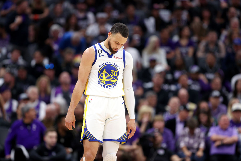 Stephen Curry #30 of the Golden State Warriors stands on the court with his head down during their ...