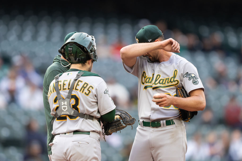 Starting pitcher Kyle Muller #39 of the Oakland Athletics (R) meets at the mound with catcher Shea ...
