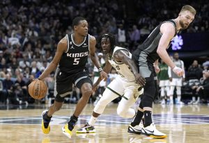 SACRAMENTO, CALIFORNIA - MARCH 13: De'Aaron Fox #5 of the Sacramento Kings dribbles around a screen set by Domantas Sabonis #10 on Jrue Holiday #21 of the Milwaukee Bucks during the fourth quarter of an NBA basketball game at Golden 1 Center on March 13, 2023 in Sacramento, California. NOTE TO USER: User expressly acknowledges and agrees that, by downloading and or using this photograph, User is consenting to the terms and conditions of the Getty Images License Agreement. (Photo by Thearon W. Henderson/Getty Images)
