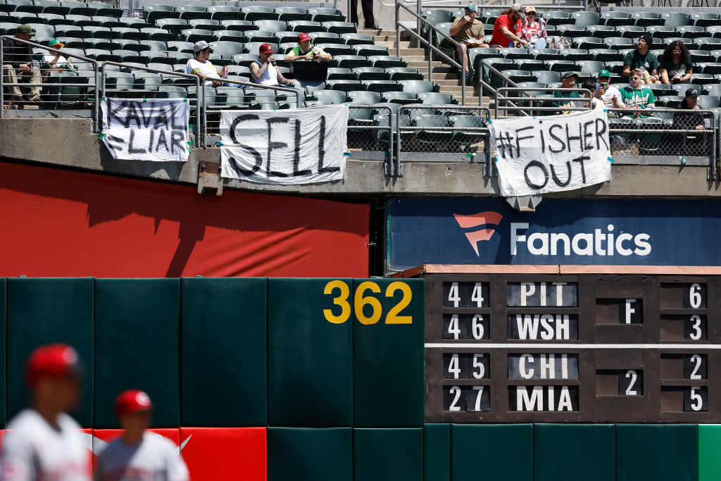 Oakland A's fans display signs during the game against the Cincinnati Reds at RingCentral Coliseum ...
