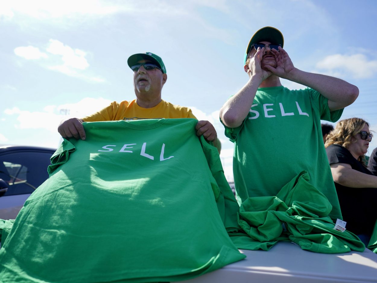 Oakland A's fans are handed out free t-shirt shirts labeled 'SELL' prior to a reverse boycott game ...