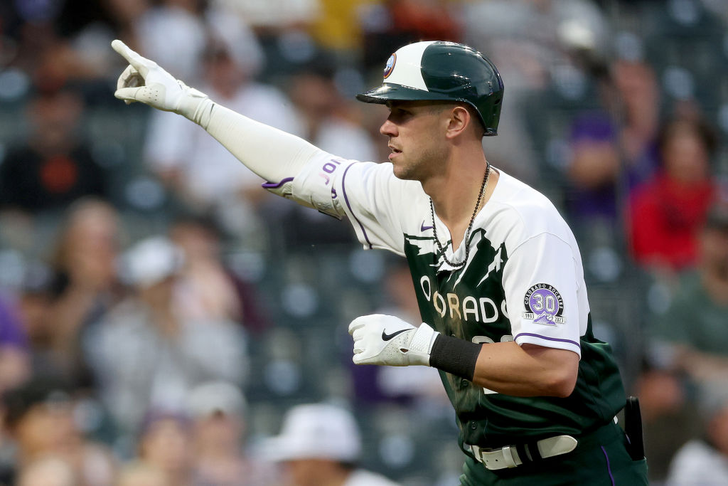 Nolan Jones #22 of the Colorado Rockies gestures after he crosses home plate after hitting a solo h...