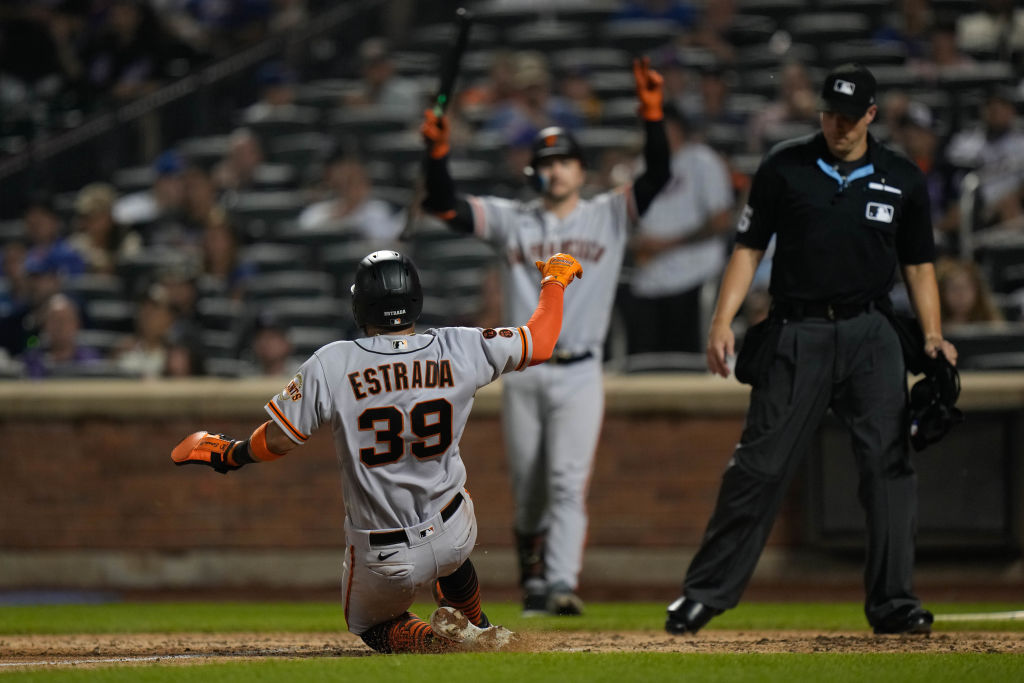 Thairo Estrada #39 of the San Francisco Giants sliding in to home plate against the New York Mets a...