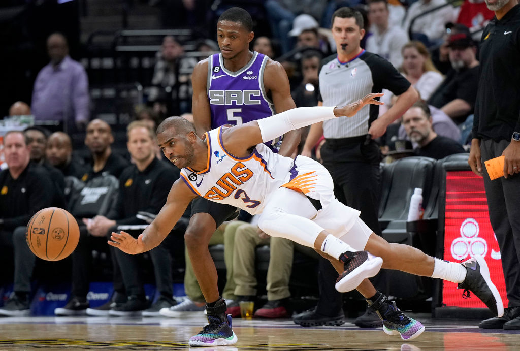 Chris Paul #3 of the Phoenix Suns dribbling the ball get fouled by De'Aaron Fox #5 of the Sacrament...