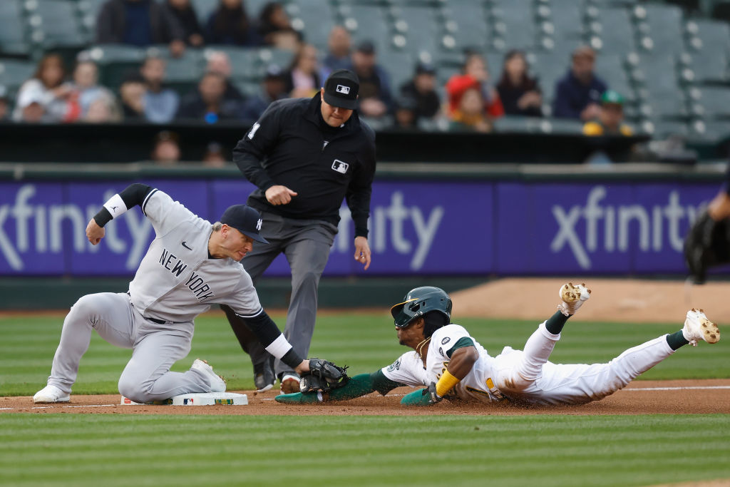 Esteury Ruiz #1 of the Oakland Athletics is tagged out stealing third base by Josh Donaldson #28 of...