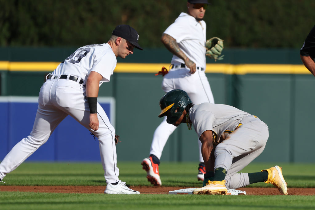 Esteury Ruiz #1 of the Oakland Athletics steals a base in the second inning next to Zack Short #59 ...