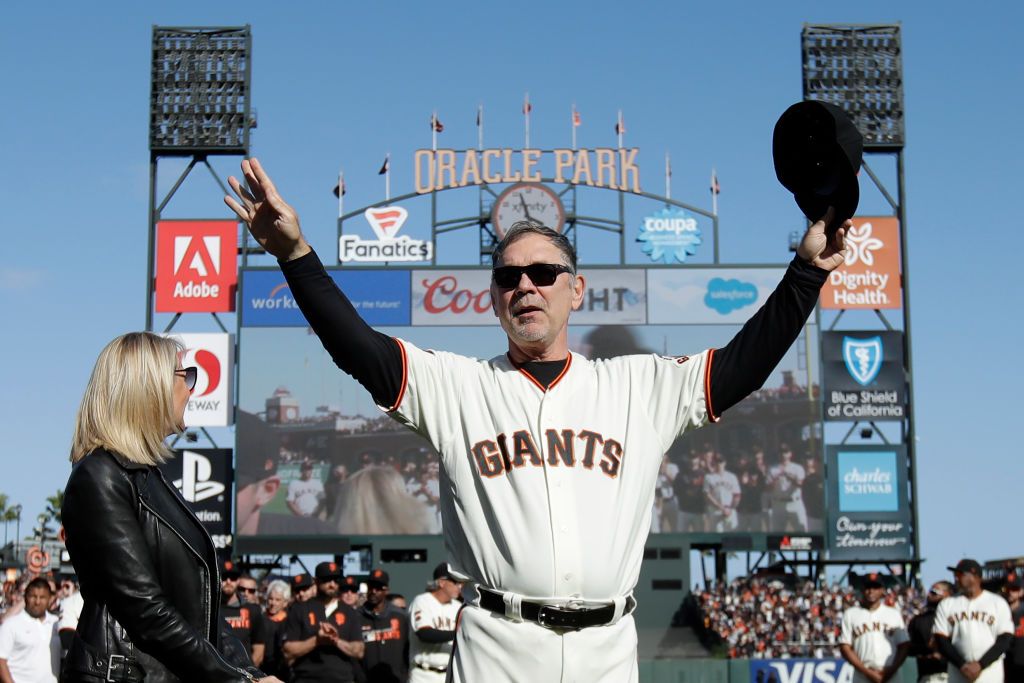 Manager Bruce Bochy #15 of the San Francisco Giants, center, gestures toward fans next to his wife ...