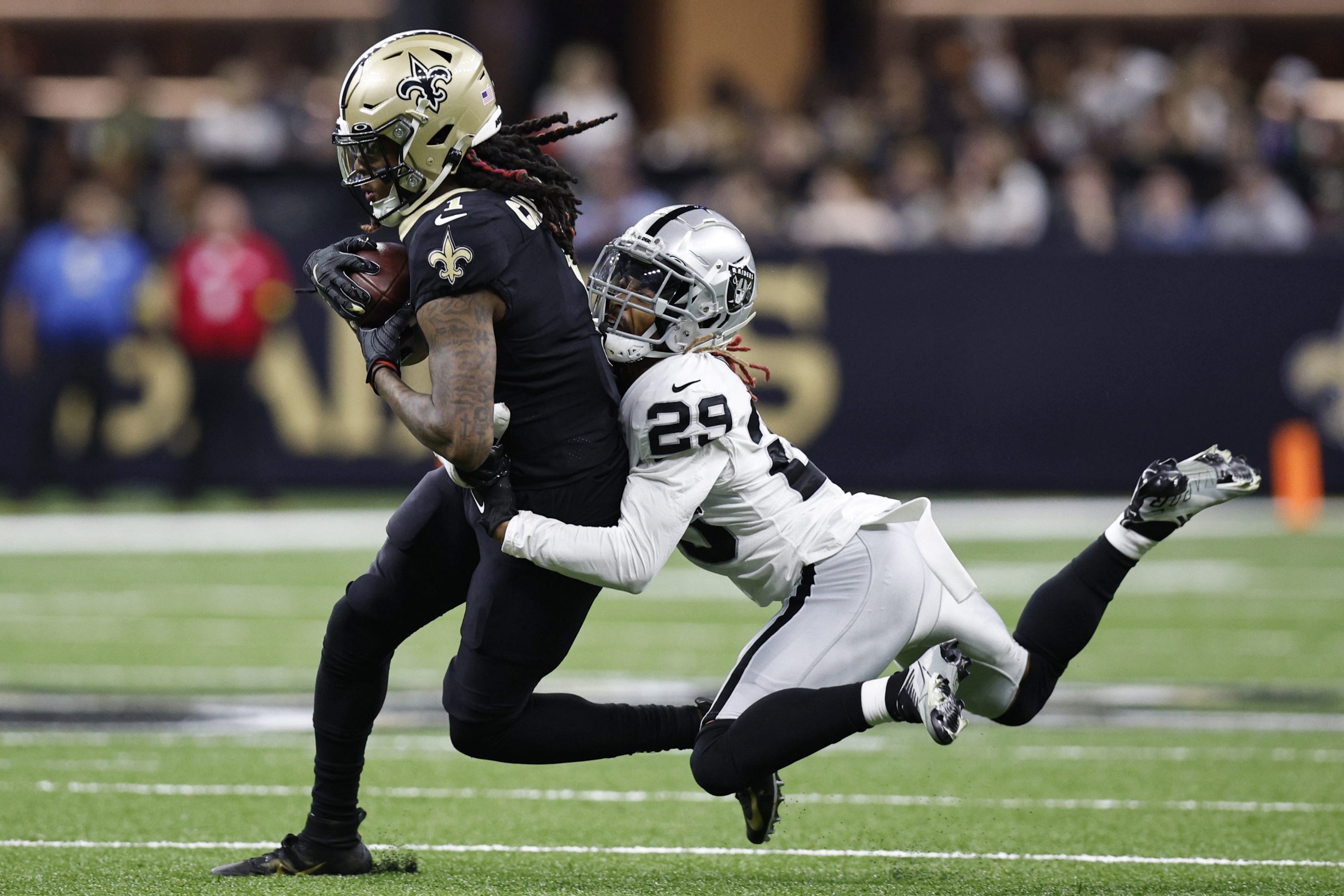 Marquez Callaway #1 of the New Orleans Saints makes a catch as he gets tackled by Anthony Averett #...