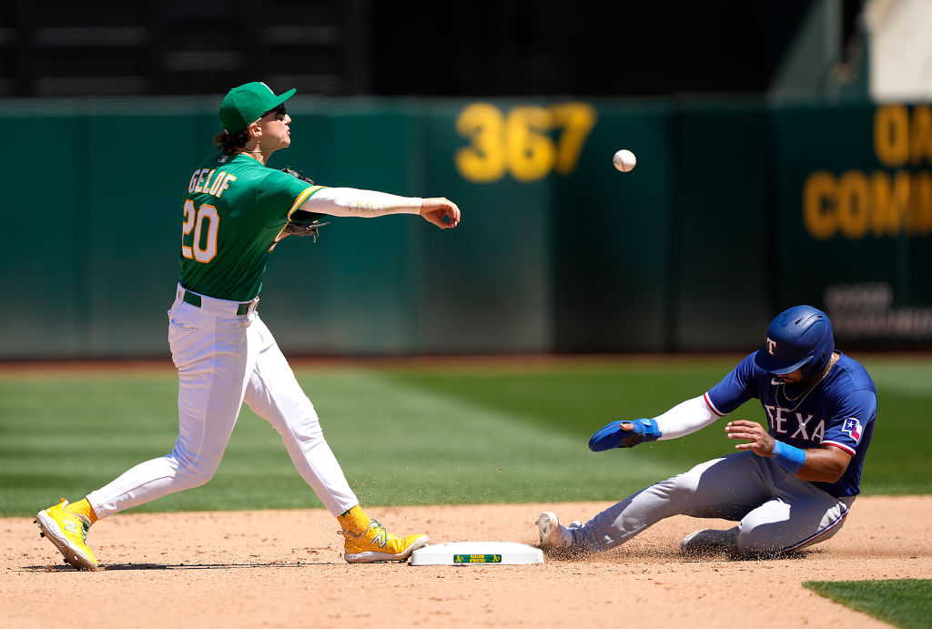 Zack Gelof #20 of the Oakland Athletics gets the out at second base and throws to first base over t...