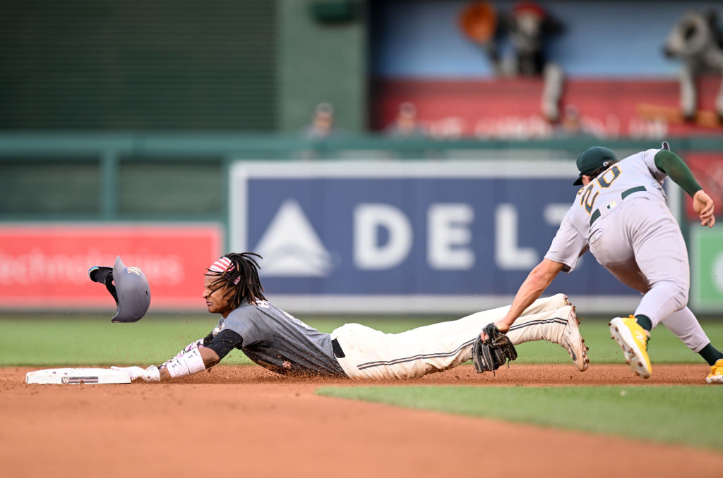 CJ Abrams #5 of the Washington Nationals is tagged out by Zack Gelof #20 of the Oakland Athletics t...