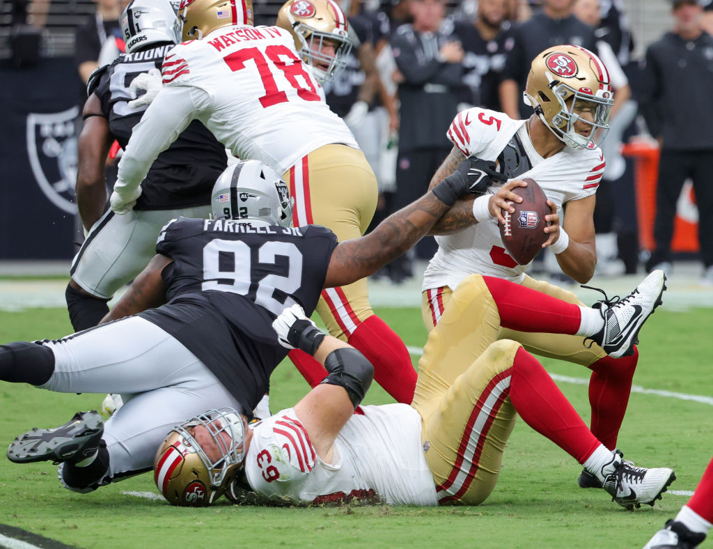 Quarterback Trey Lance #5 of the San Francisco 49ers escapes a sack attempt by defensive tackle Nei...