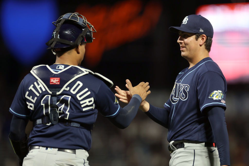 Jacob Lopez #74 shakes hands with Christian Bethancourt #14 of the Tampa Bay Rays after they beat t...