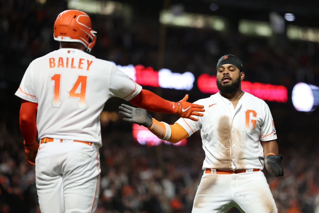 Heliot Ramos #12 of the San Francisco Giants is congratulated by Patrick Bailey #14 after he scored...