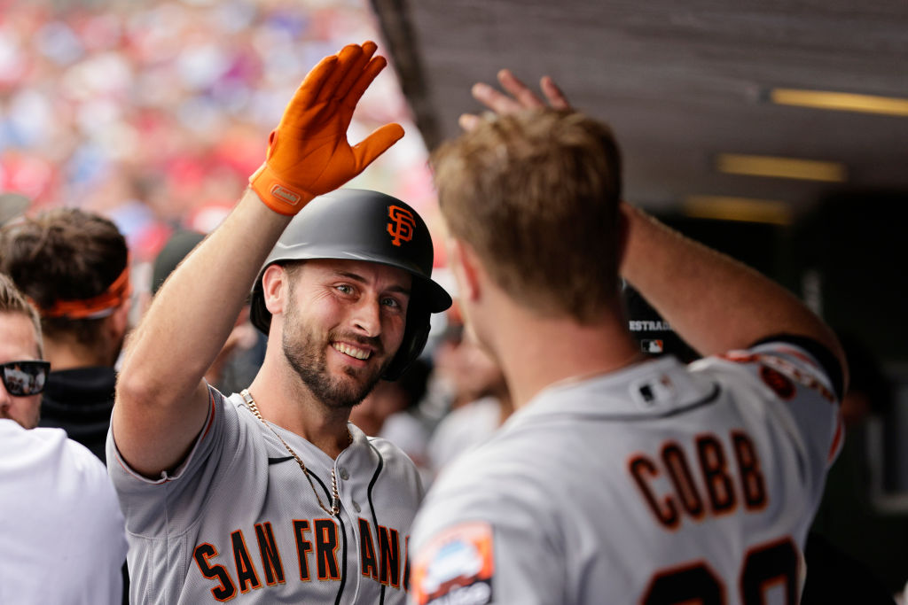 Paul DeJong #18 of the San Francisco Giants is congratulated by pitcher Alex Cobb #38 after hitting...