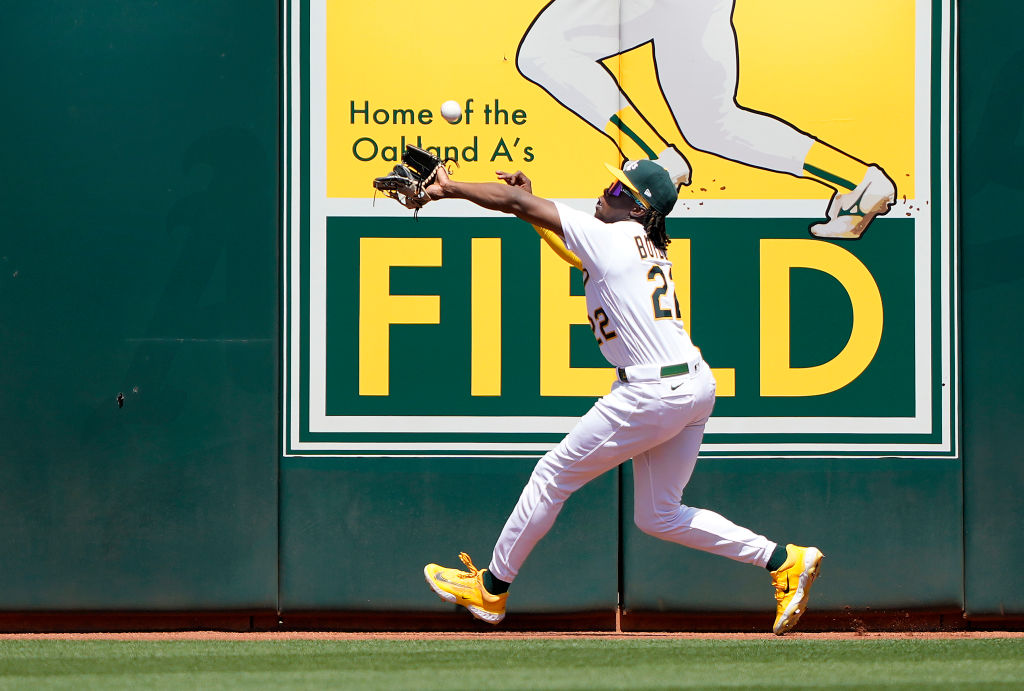 Lawrence Butler #22 of the Oakland Athletics watches the ball go over his glove and off the wall fo...