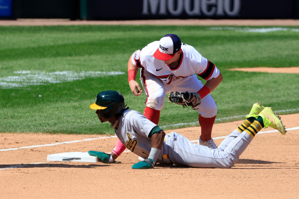 Andrew Vaughn #25 of the Chicago White Sox attempts to tag Esteury Ruiz #1 of the Oakland Athletics...