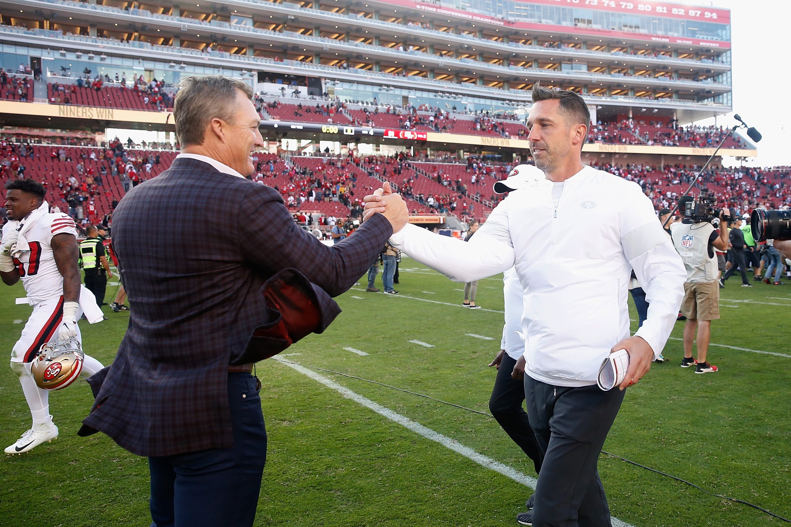 San Francisco 49ers General Manager John Lynch congratulates head coach Kyle Shanahan after a win a...