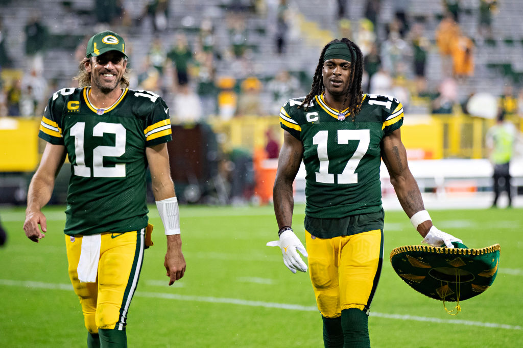 Aaron Rodgers #12 and Davante Adams #17 of the Green Bay Packers walk off the field together after ...