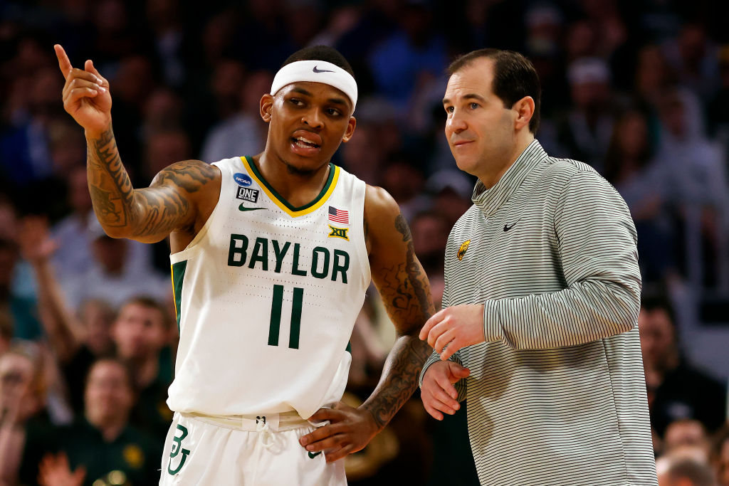 James Akinjo #11 of the Baylor Bears talks with head coach Scott Drew in the first half of the game...