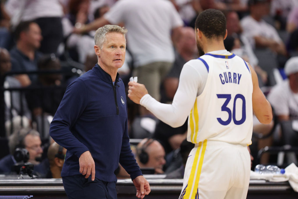 Head coach Steve Kerr of the Golden State Warriors talks with Stephen Curry #30 during game seven o...