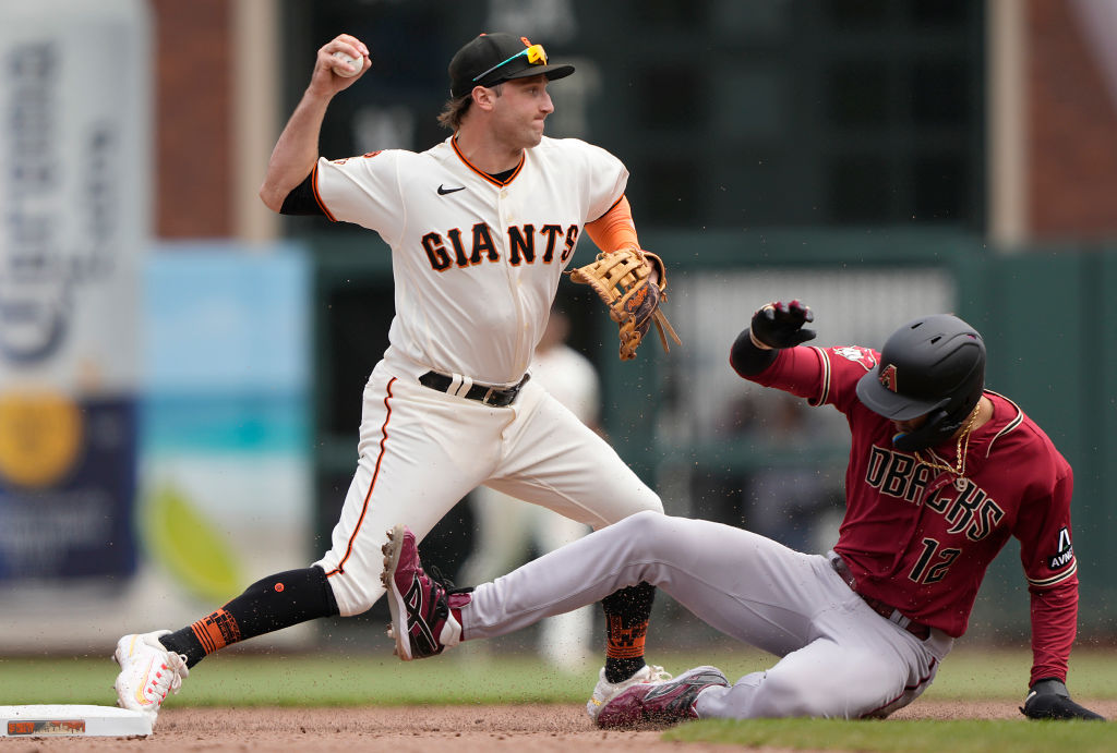 Casey Schmitt #6 of the San Francisco Giants looks to throw to first base after getting the out at ...