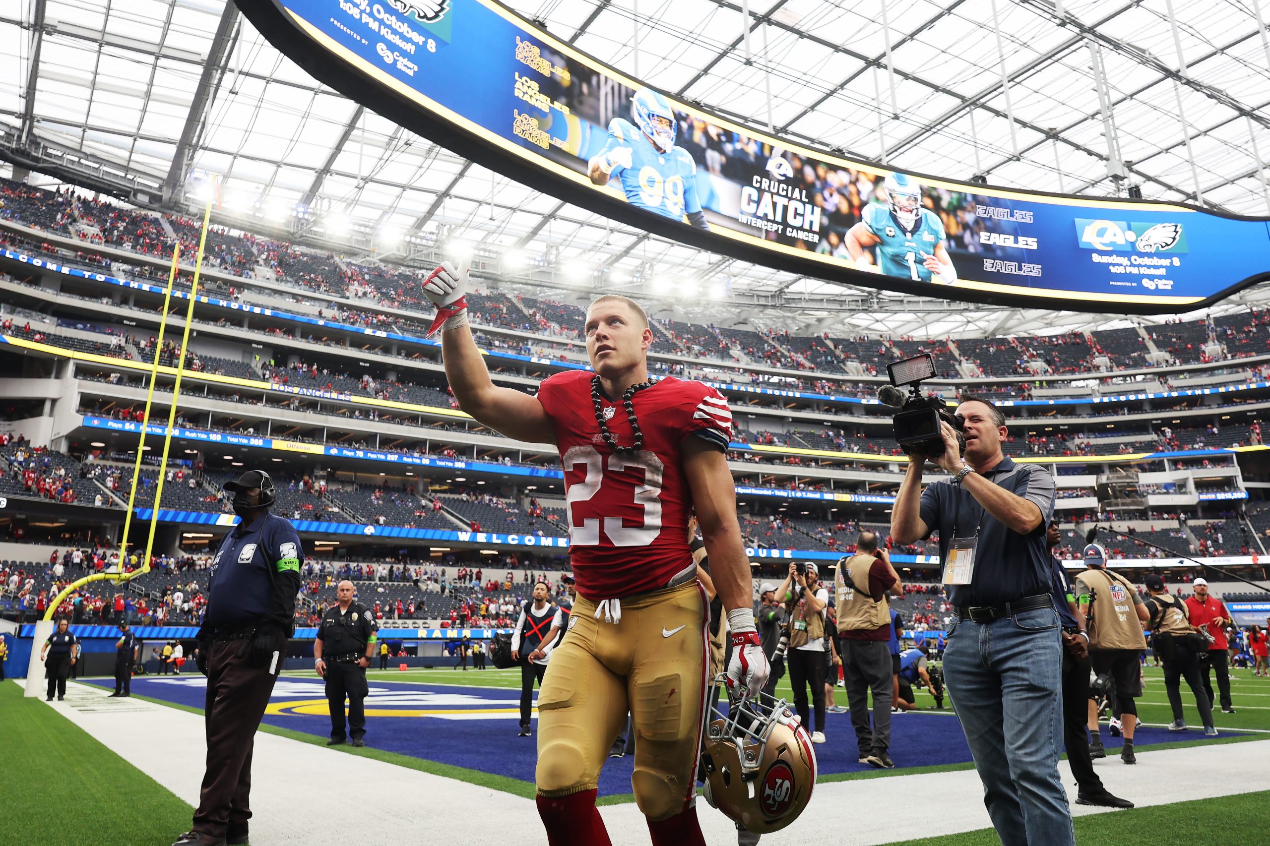 Christian McCaffrey #23 of the San Francisco 49ers waves to fans as he leaves the field after the g...