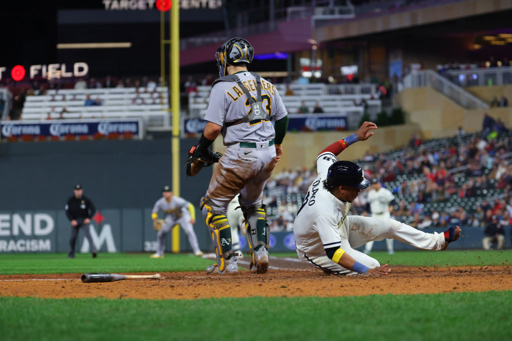 Jorge Polanco #11 of the Minnesota Twins slides home for a run in the seventh inning against the Oa...