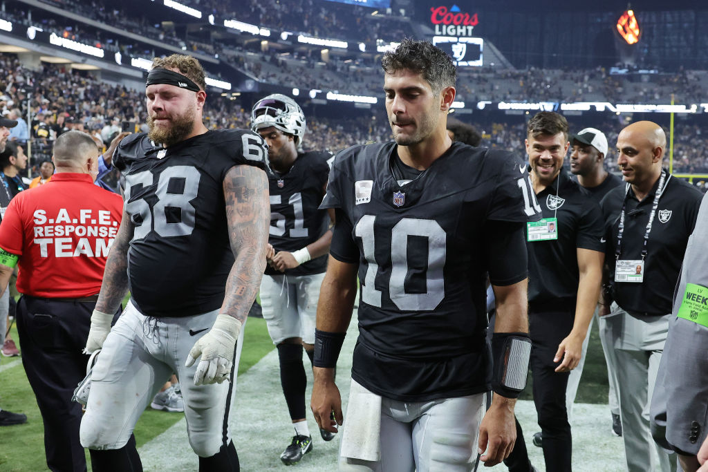 Center Andre James #68 and quarterback Jimmy Garoppolo #10 of the Las Vegas Raiders walk off the fi...