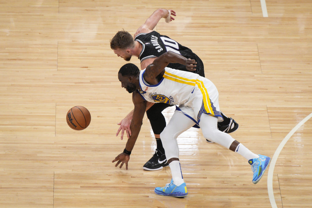 Draymond Green #23 of the Golden State Warriors goes for a loose ball against Domantas Sabonis #10 ...
