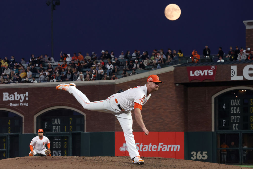 Alex Cobb #38 of the San Francisco Giants pitches against the Cincinnati Reds as a almost full moon...