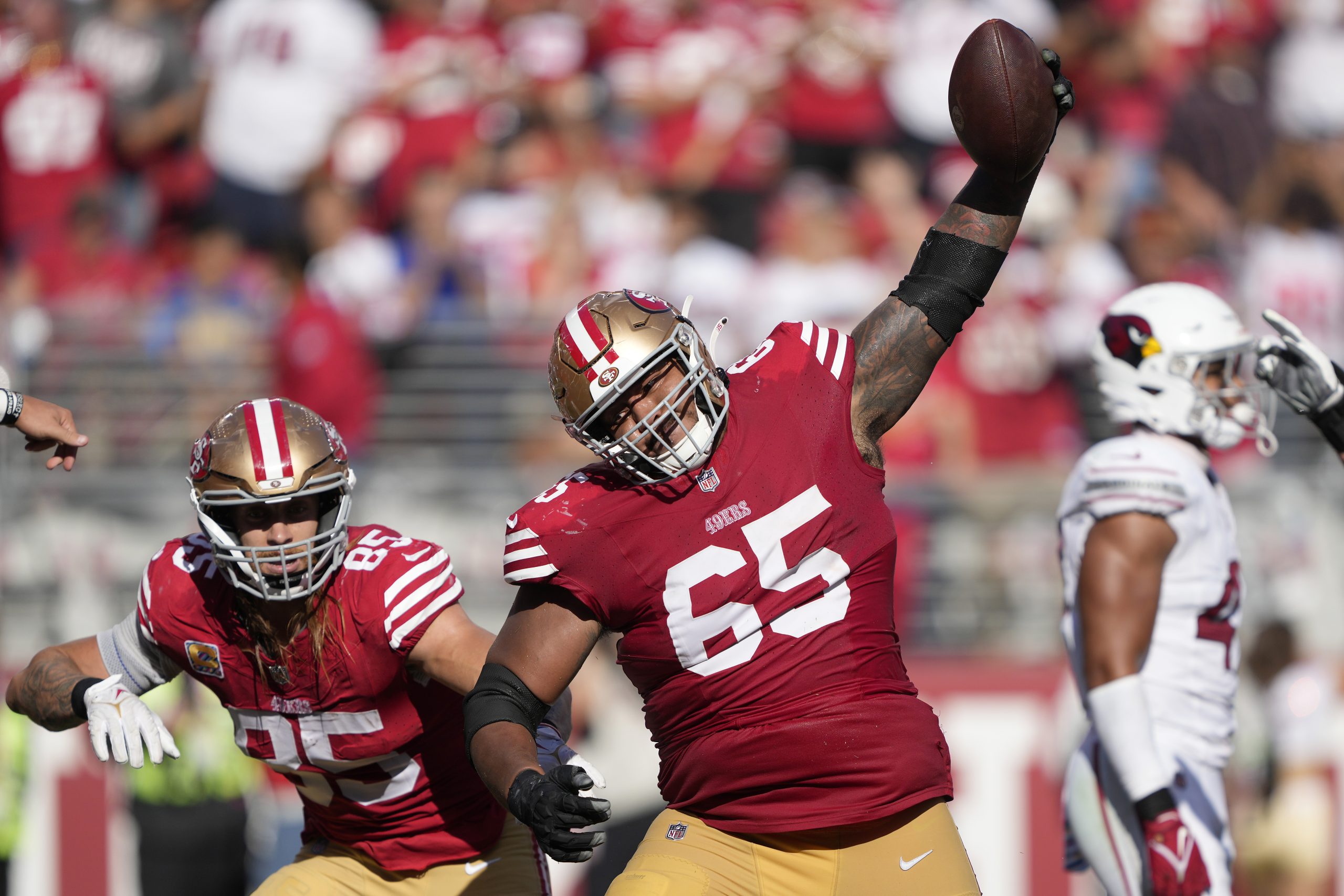 Aaron Banks #65 of the San Francisco 49ers spikes the ball to celebrate a rushing touchdown by Broc...