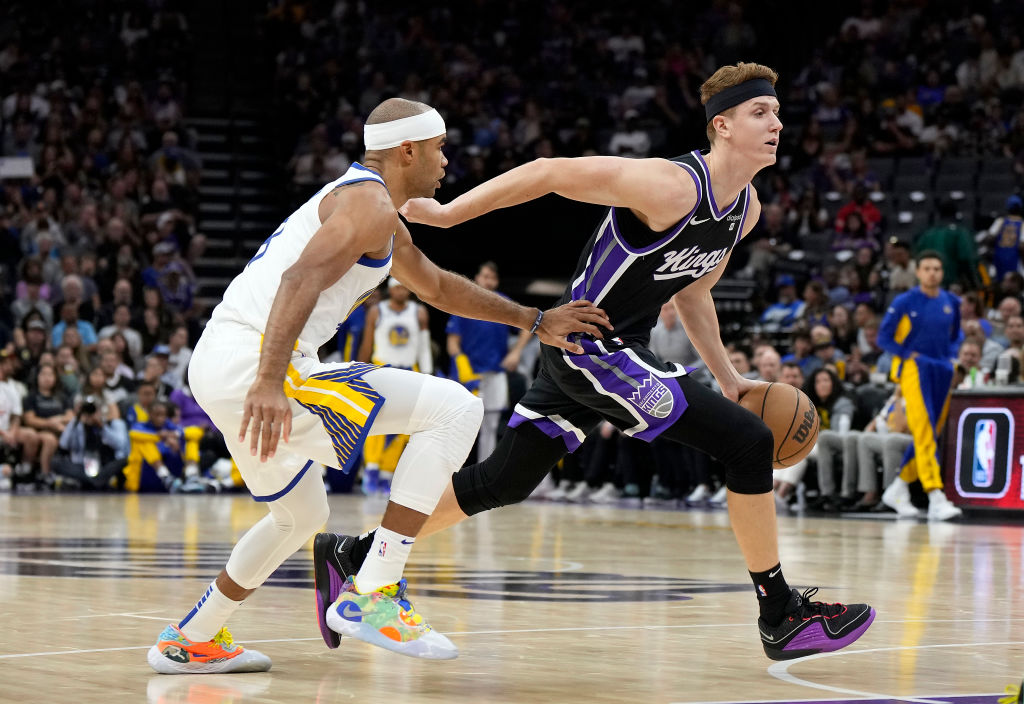 Kevin Huerter #9 of the Sacramento Kings dribbles the ball past Jerome Robinson #18 of the Golden S...