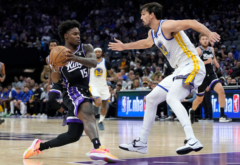 Davion Mitchell #15 of the Sacramento Kings drives on Dario Saric #20 of the Golden State Warriors ...