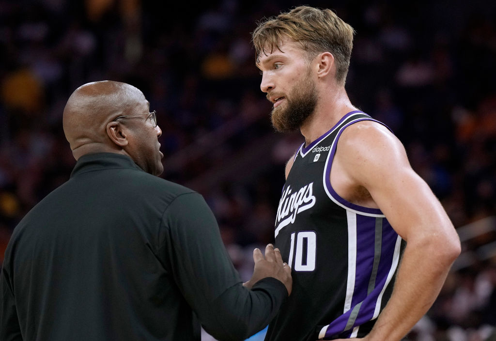Head coach Mike Brown of the Sacramento Kings talks with his player Domantas Sabonis #10 against th...