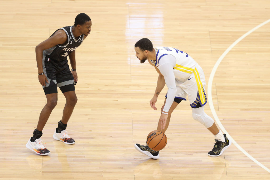 Stephen Curry #30 of the Golden State Warriors dribbles against De'Aaron Fox #5 of the Sacramento K...