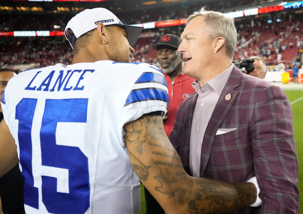 Trey Lance #15 of the Dallas Cowboys talks with general manager John Lynch of the San Francisco 49e...