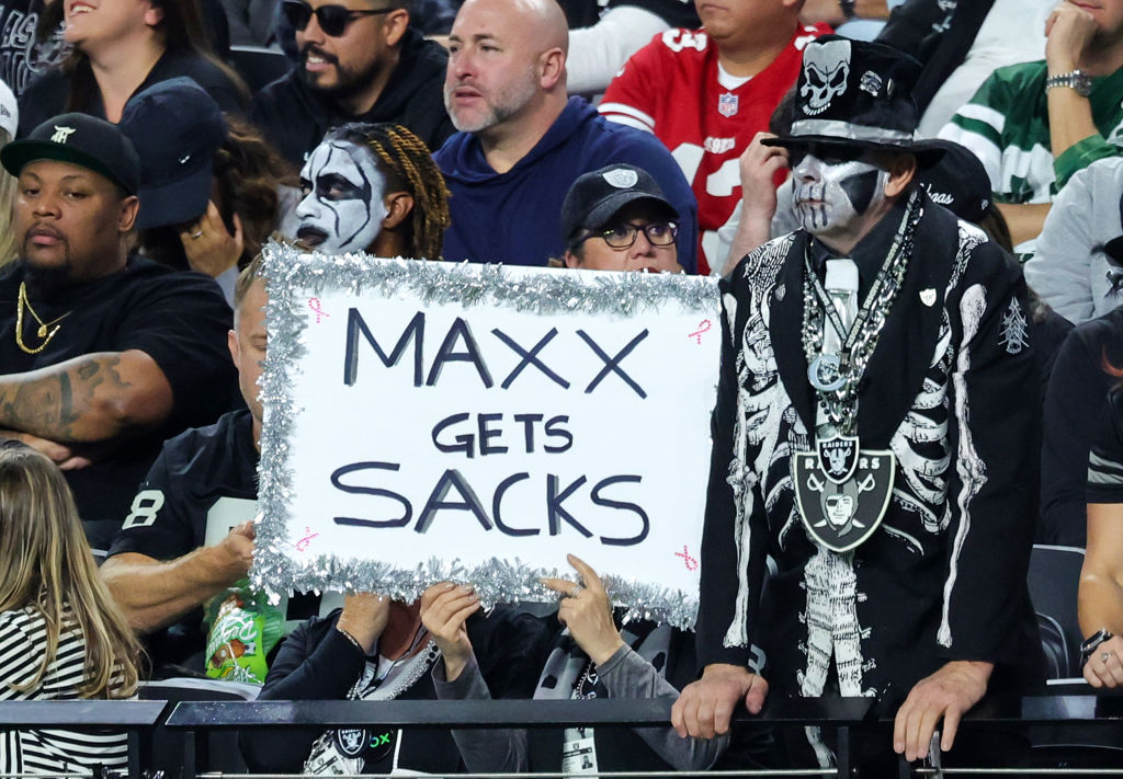 A fan holds a sign referencing defensive end Maxx Crosby #98 of the Las Vegas Raiders in the third ...