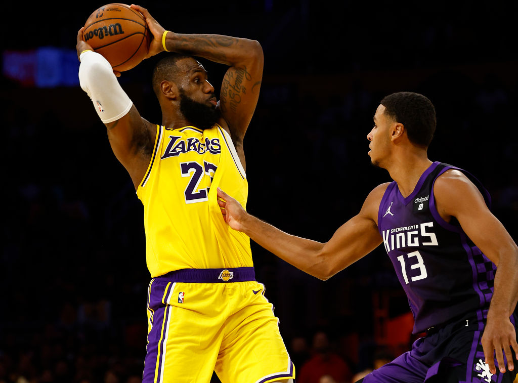 LeBron James #23 of the Los Angeles Lakers controls the ball against Keegan Murray #13 of the Sacra...