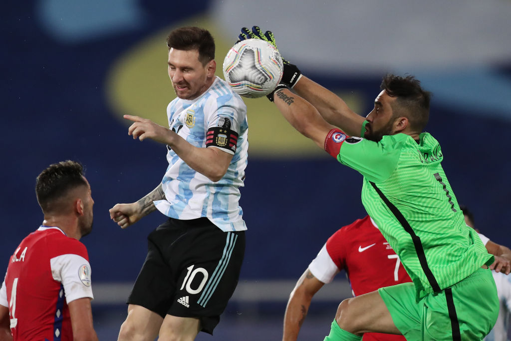 Lionel Messi of Argentina jumps for the ball against Claudio Bravo goalkeeper of Chile during a Gro...