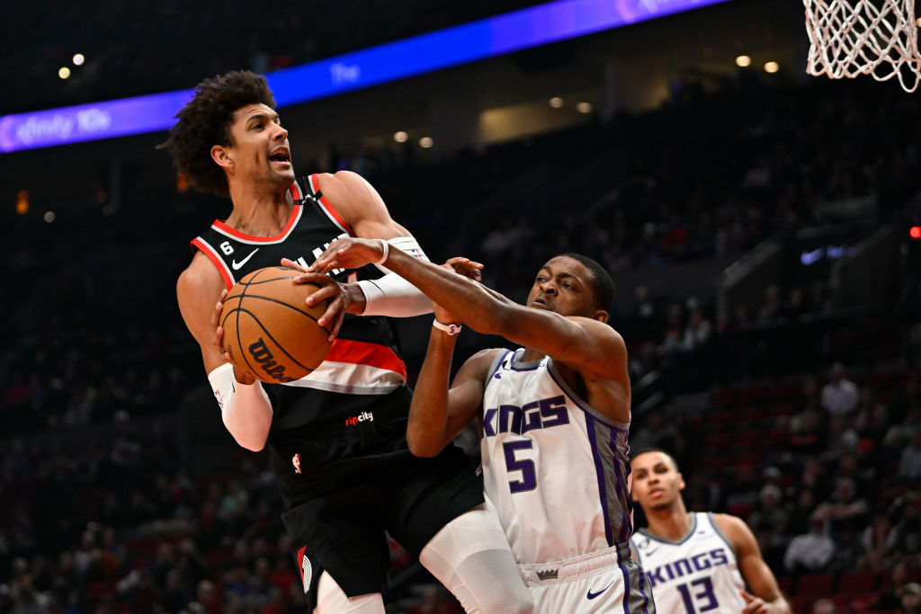 Matisse Thybulle #4 of the Portland Trail Blazers is fouled by De'Aaron Fox #5 of the Sacramento Ki...